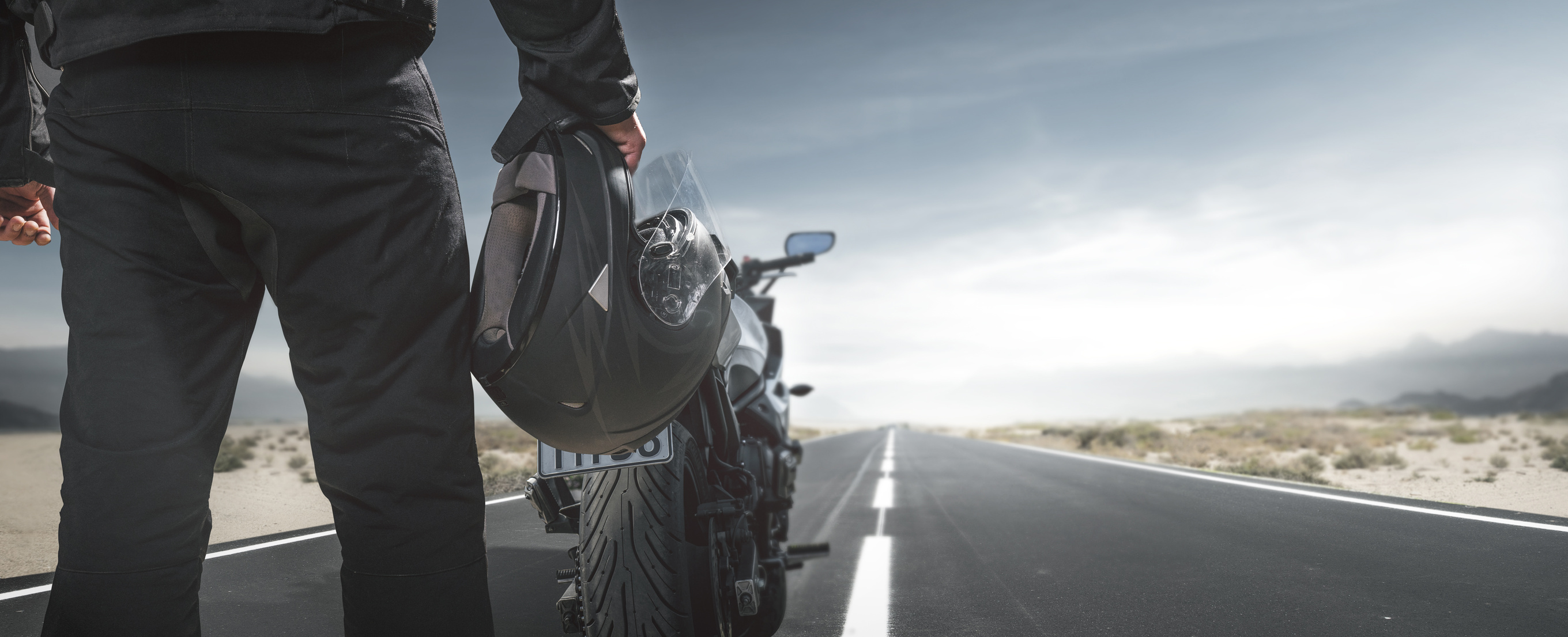 Biker with motorcycle on a country road